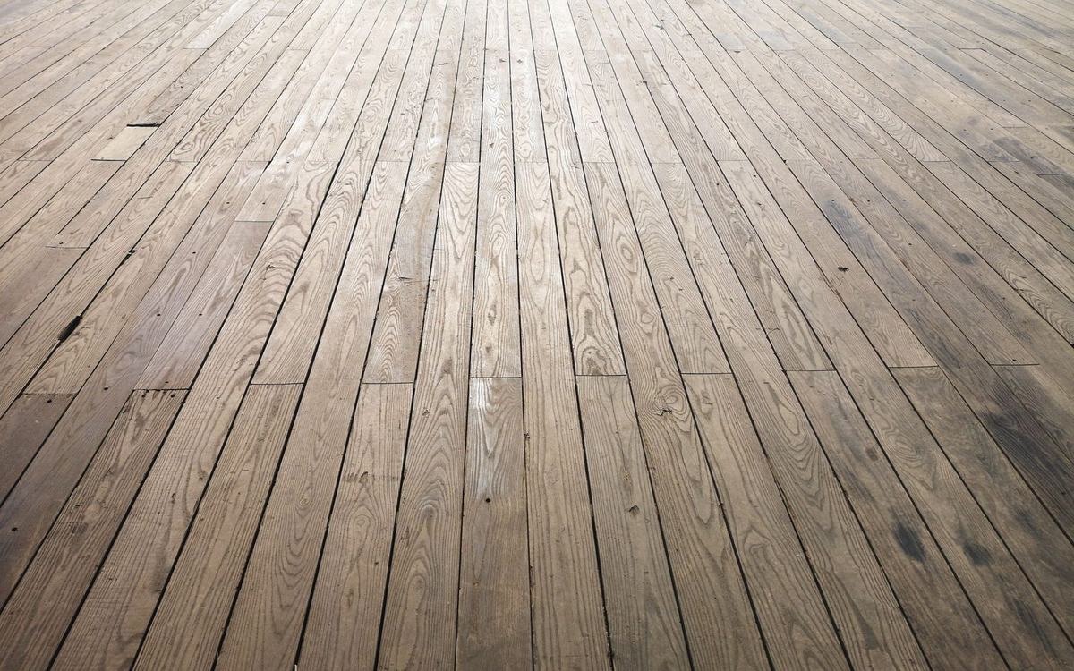 Old pine floorboards showing wear before sanding and refinishing